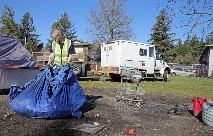 A member of Cultivate Initiatives' Community Beautification crew cleaning up trash.