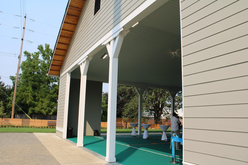 A green sports court is under the covered awning of the beige-colored building of Plaza Los Amigos affordable housing project in Cornelius.