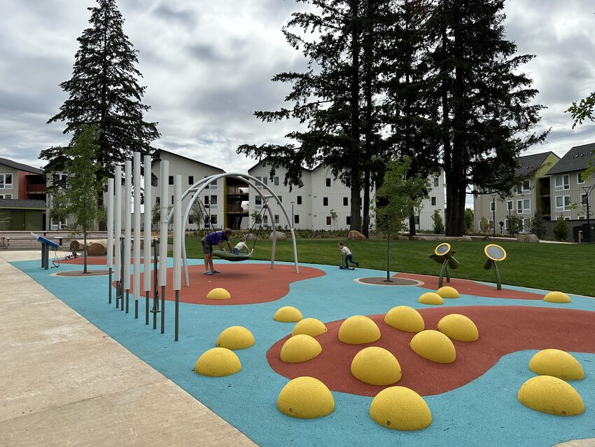 Playground with colorful ground material and yellow mounds.