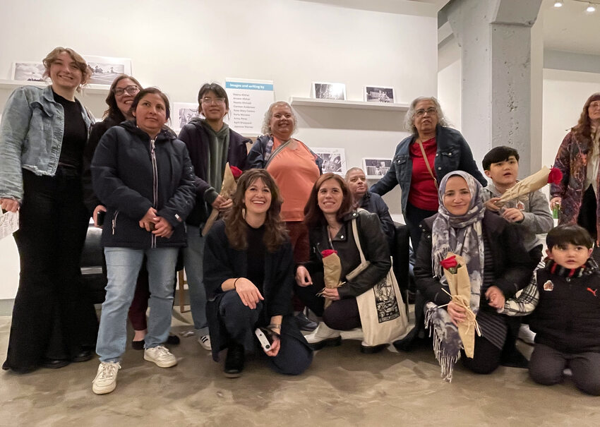 Group of people posing for a photo in a gallery setting.