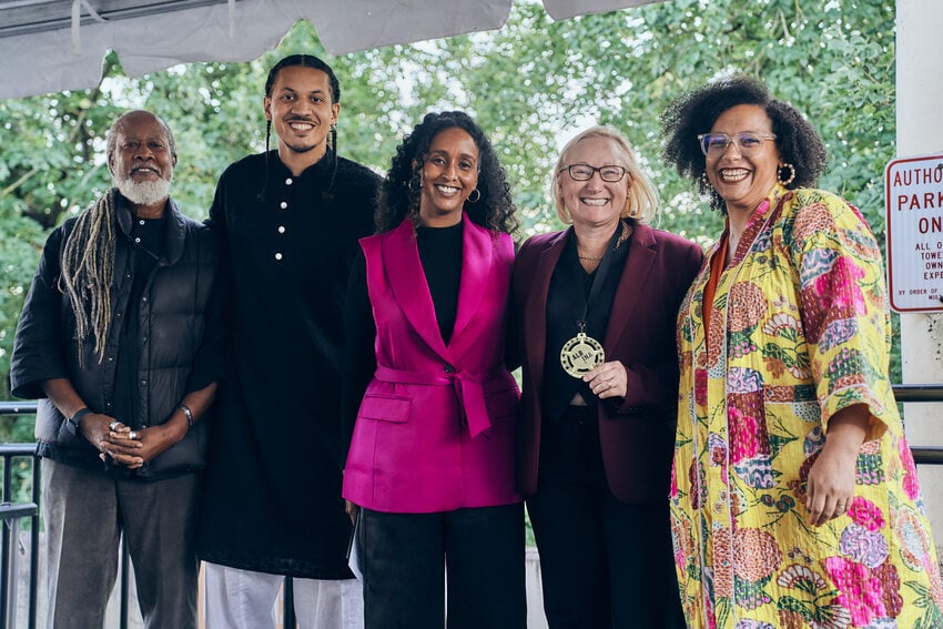 4 board members and a commissioner stand in a line wearing colorful clothing