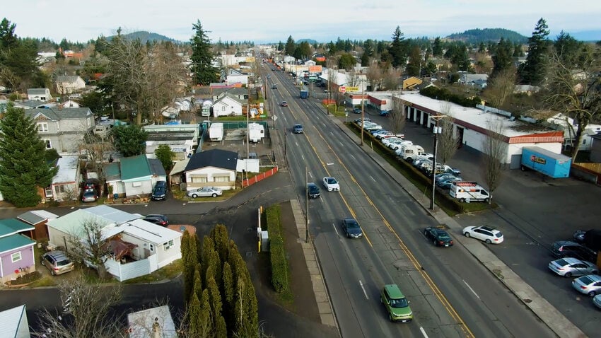 An aerial view of a four lane street and surrounding buildings.