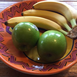 green apples and bananas in a bowl