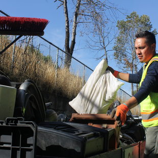 Photo of RID Patrol crew supervisor Juan Garcia loading truck with garbage