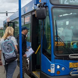 TriMet line 72 at MAX connection bus stop with riders boarding