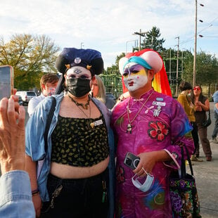 Two people in nun drag posing for a photo outside a celebration.