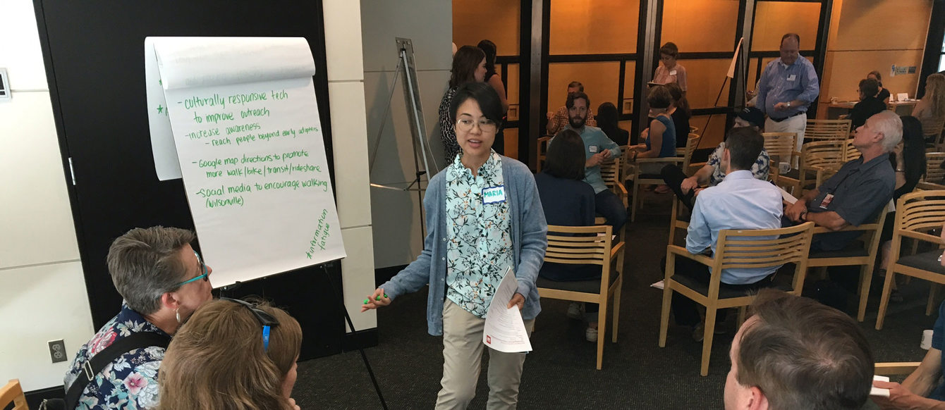 woman speaking to people and writing comments on a flipchart during a meeting in Metro Regional Center