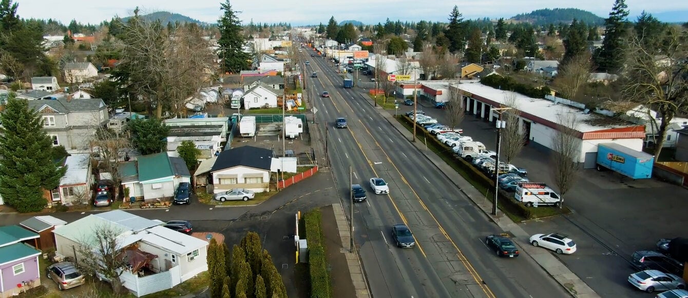 An aerial view of a four lane street and surrounding buildings.