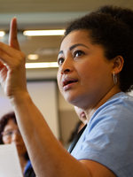Woman raising her hand and speaking to a group