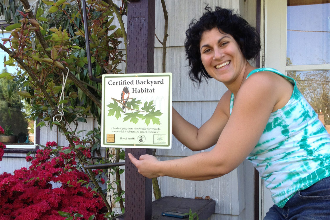 photo of woman with backyard habitat sign