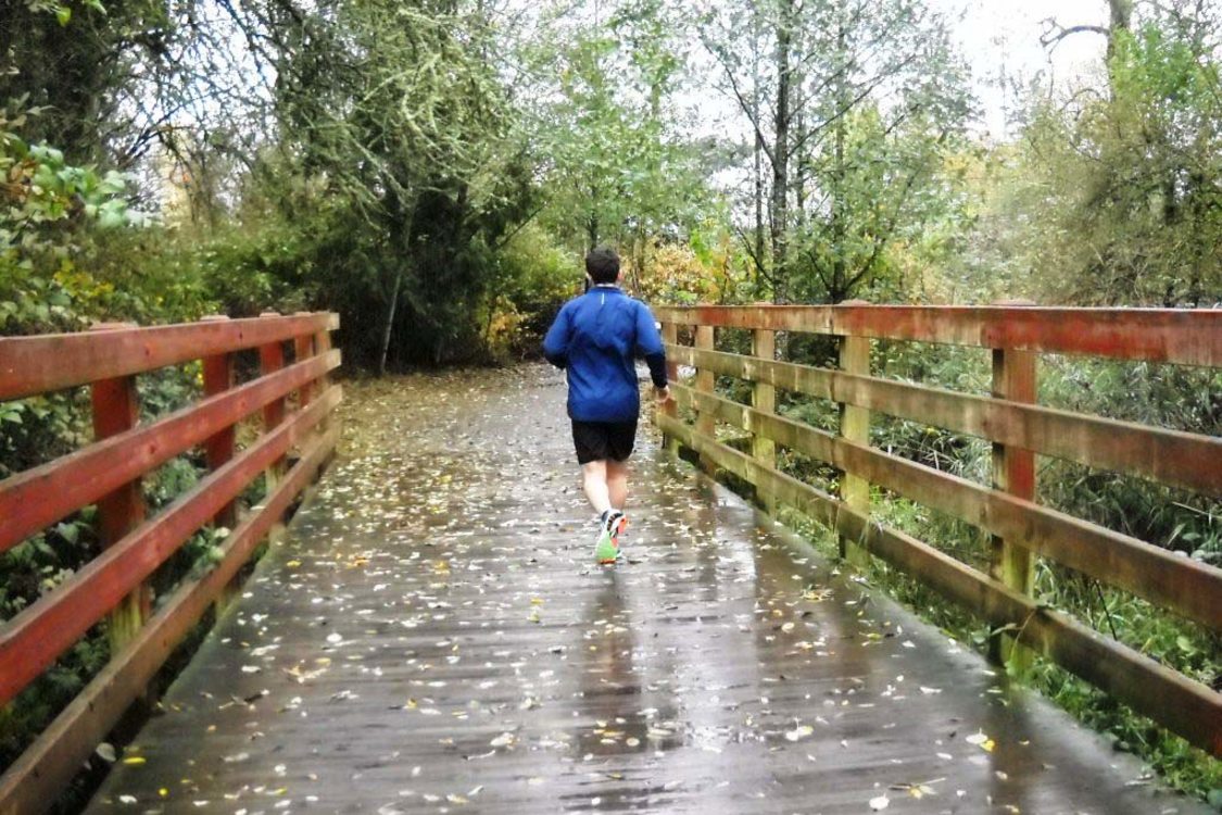 photo of jogger on tributary bridge