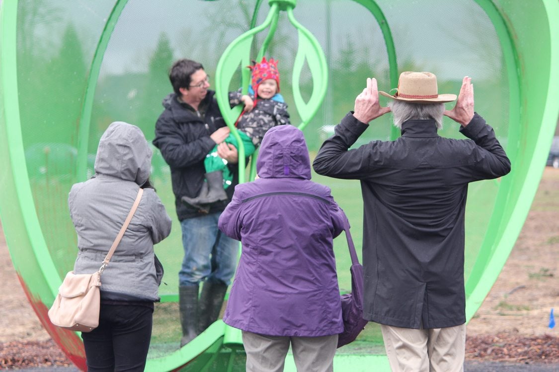 visitors enjoy apple art structure at Orenco Woods Nature Park