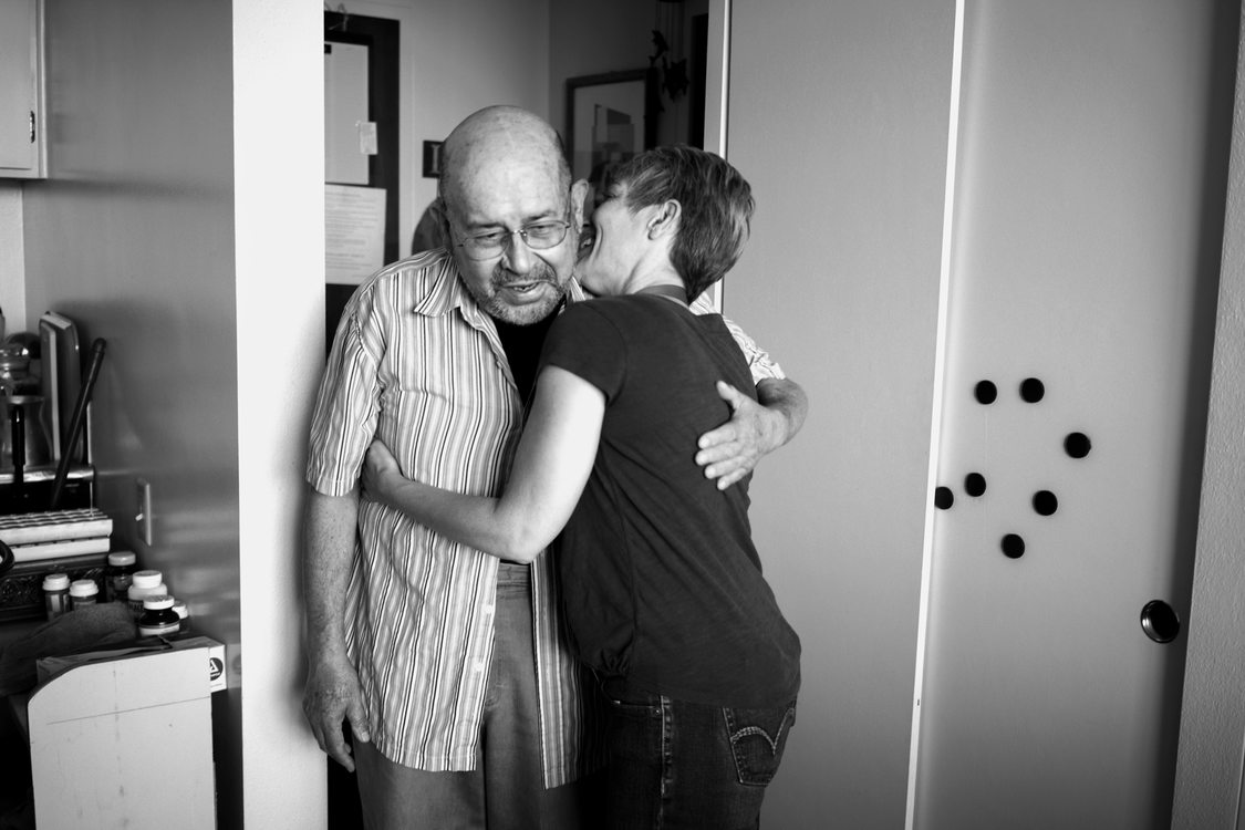 a volunteer gives an elderly client a hug