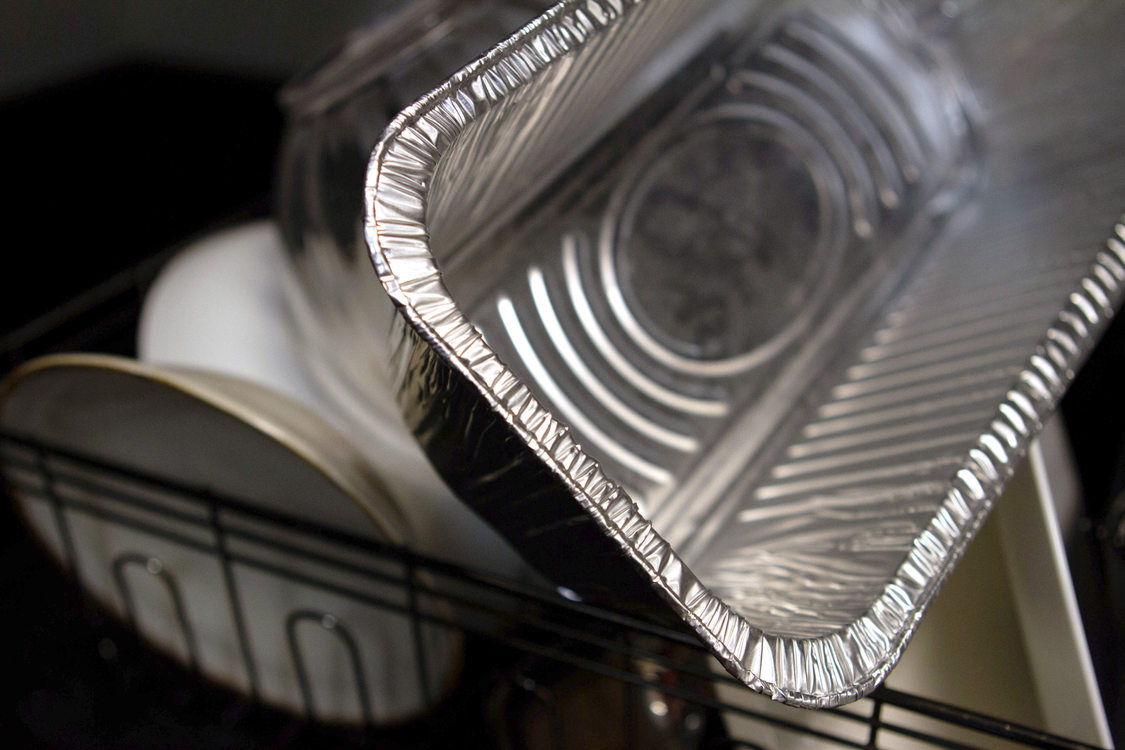 a clean foil serving tray sits in a dish rack