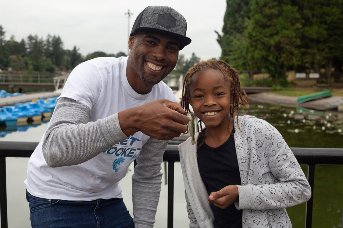Dishaun Berry of Get Hooked poses with a girl and a fish she caught at Blue Lake Park.