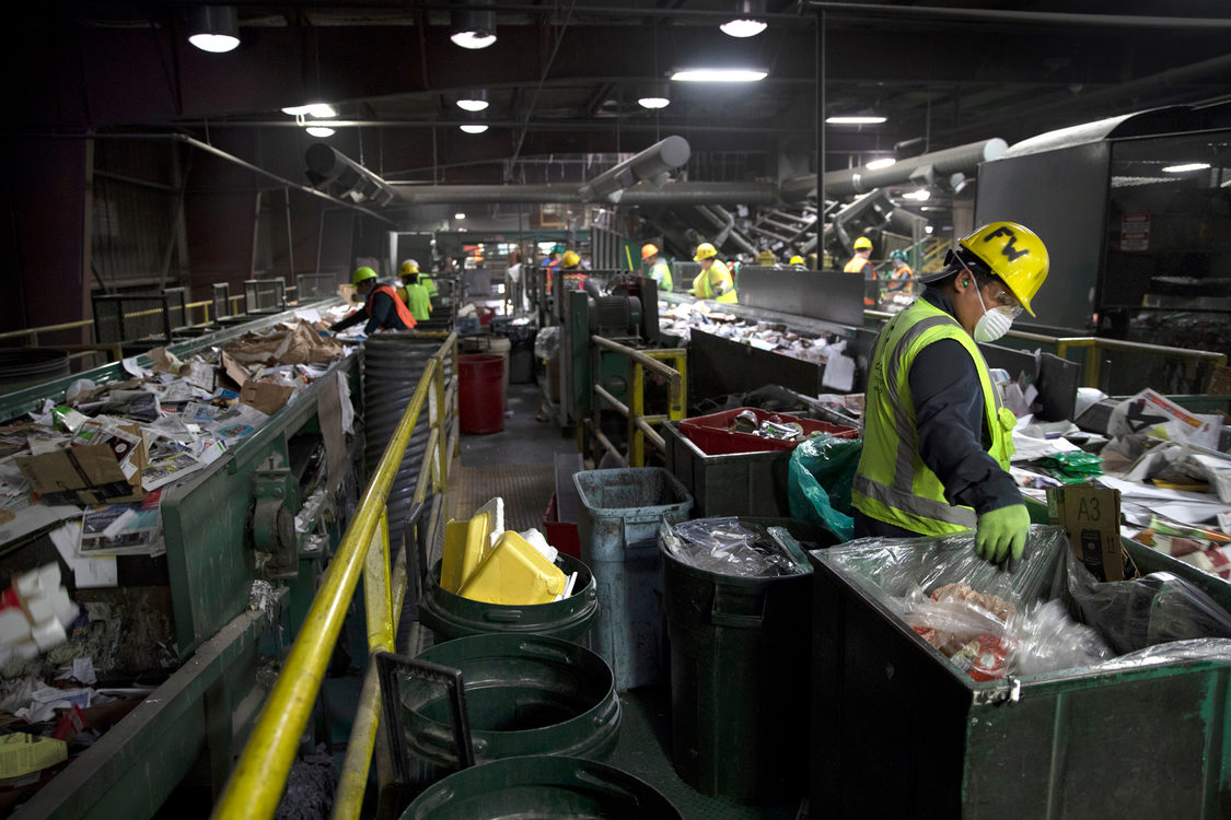 recycling facility workers sort items
