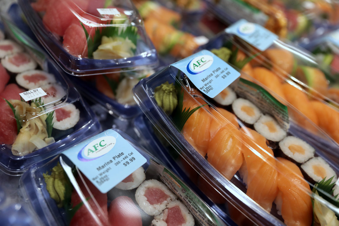 Grocery store deli section offering sushi in plastic take out containers