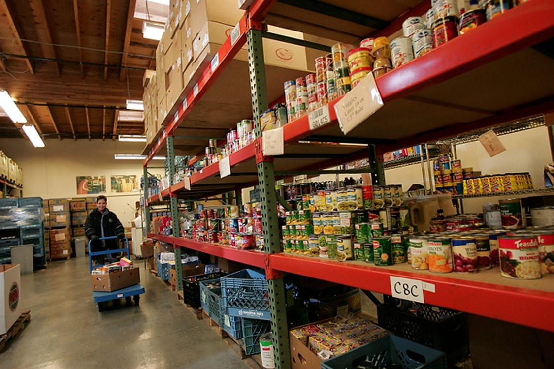 woman stocking the shelves at a food donation warehouse