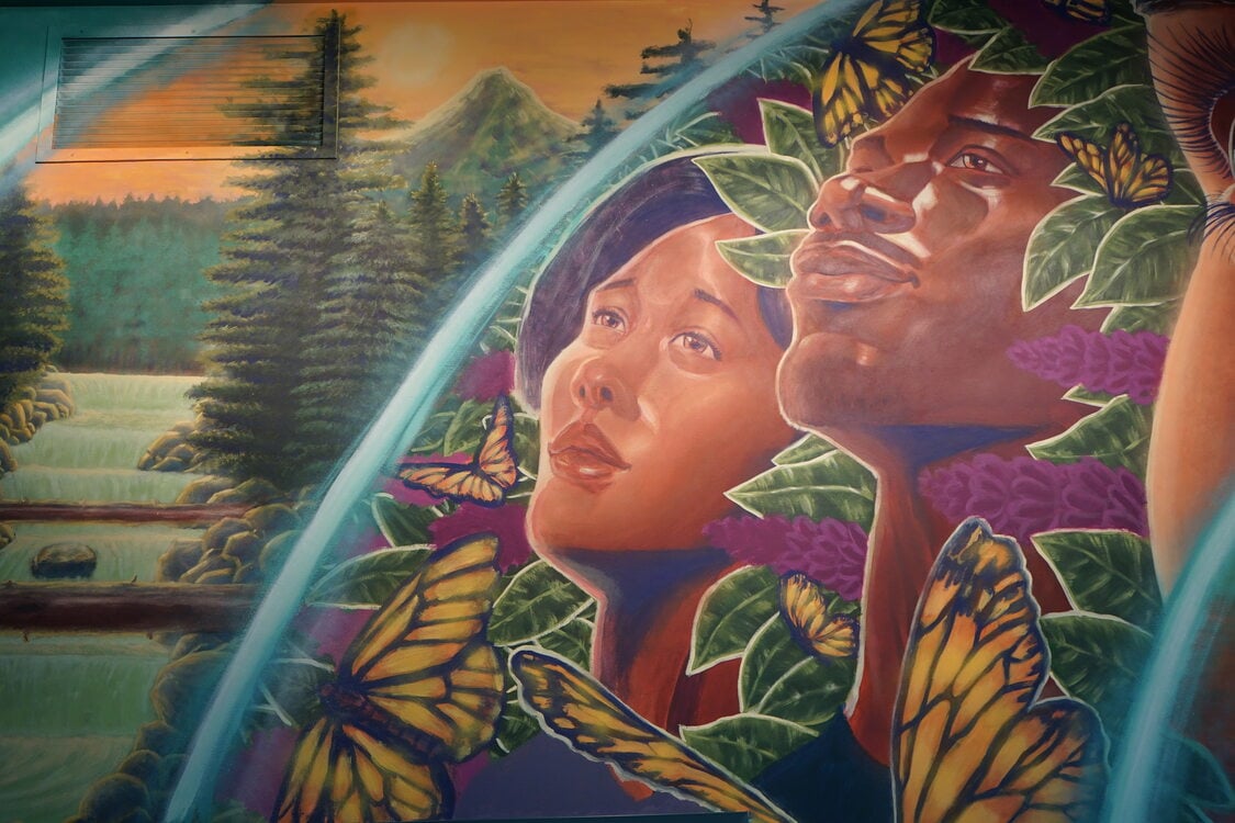 Mural with two African American people in a forest scene with butterflies. 