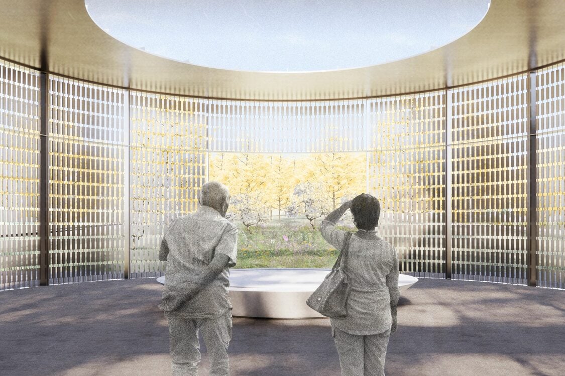 Two figures seen from behind stand before a low, round stone altar surrounded by a circular screen of metal tiles.