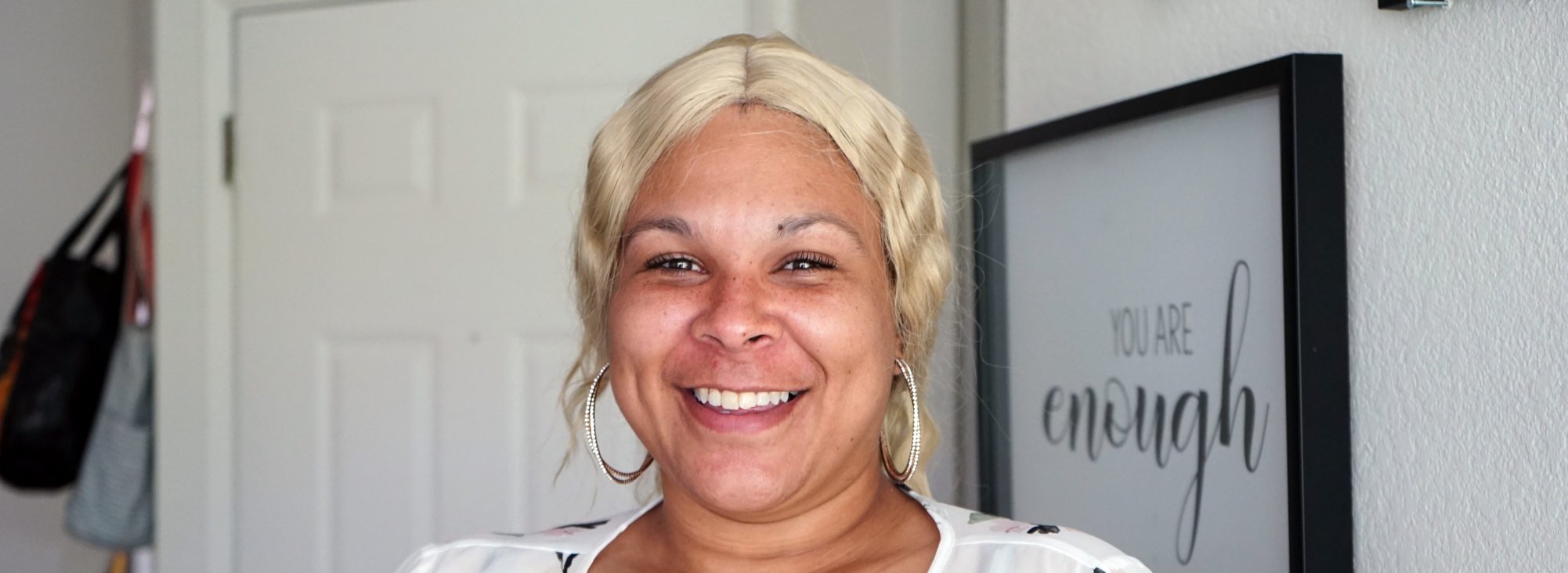 Smiling woman in white blouse with platinum blonde hair. 