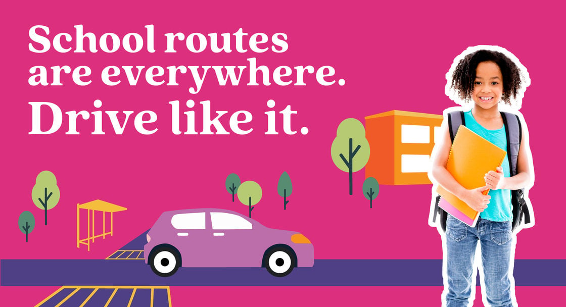 Safety campaign poster with text saying "School routes are everywhere. Drive like it" in English. A child is wearing a backpack and carrying a folder with an animated background