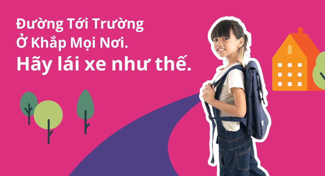 A child wearing a backpack appears in a safety campaign poster with a message in Vietnamese reading "School routes are everywhere. Drive like it."