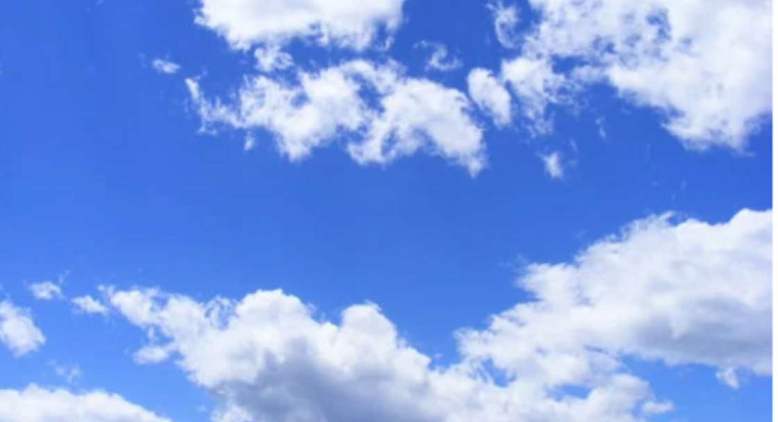 Fluffy white clouds against a blue sky.